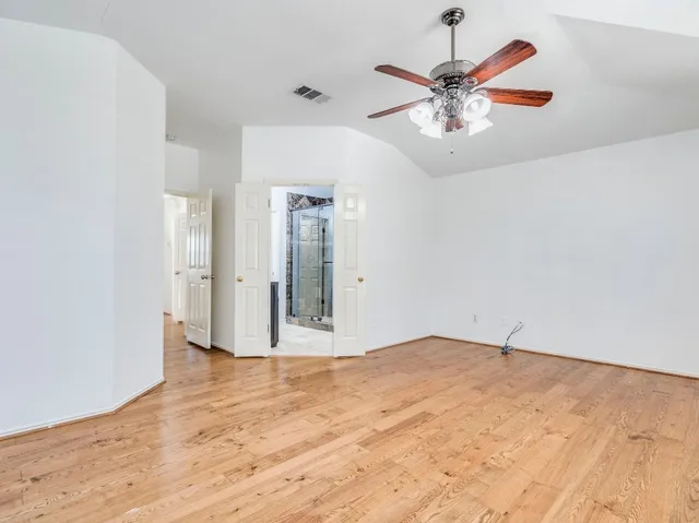 a view of an empty room with a ceiling fan