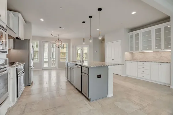 a large kitchen with stainless steel appliances granite countertop a large counter top and a stove