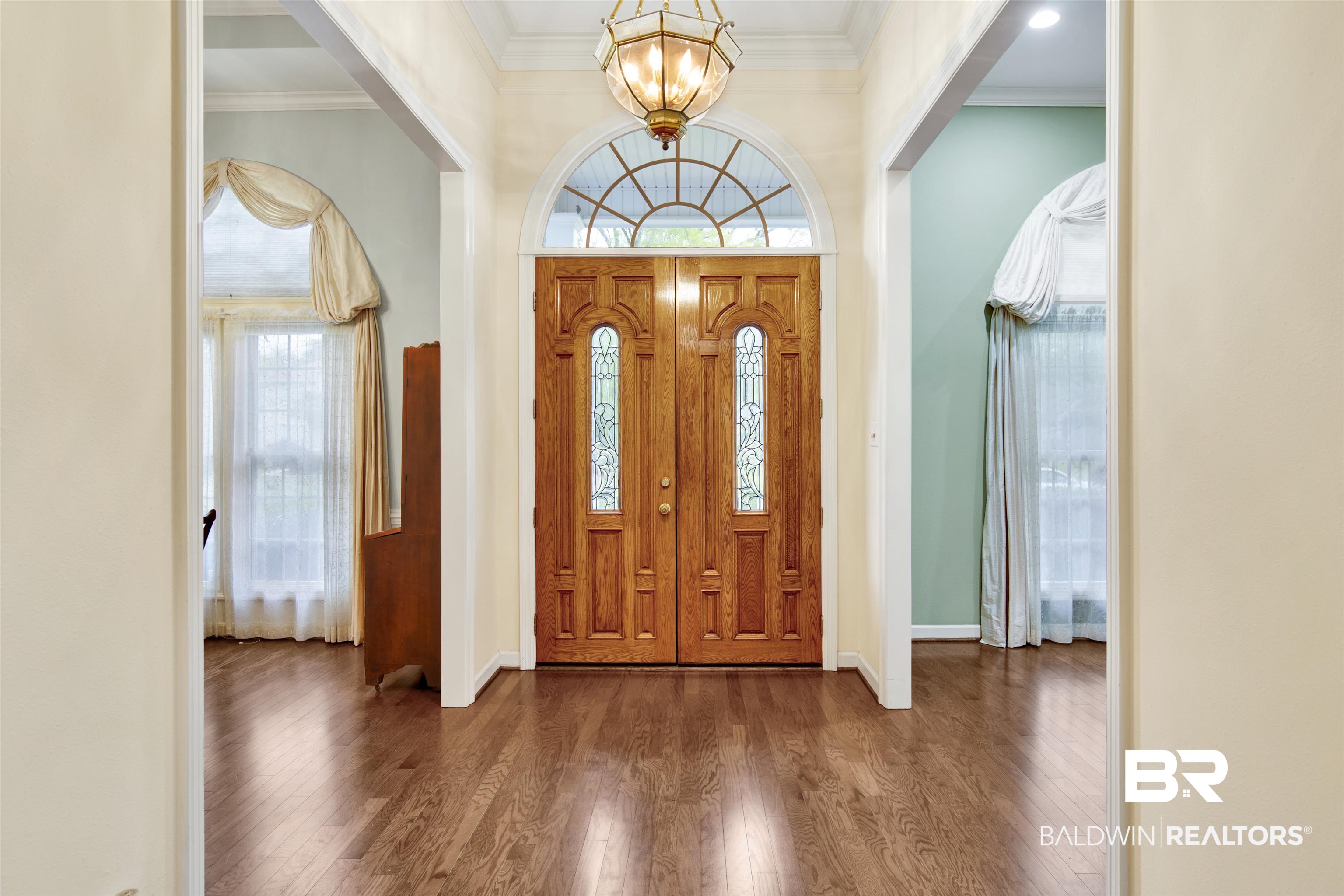 106 Old Mill Road Fairhope, AL 36532 - Photo 5 of 49 Foyer entrance featuring an inviting chandelier, ornamental molding, baseboards, and wood finished floors