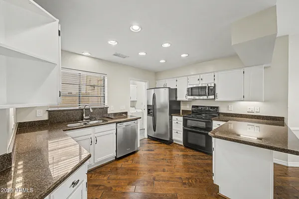 a kitchen with stainless steel appliances granite countertop a sink stove oven and refrigerator