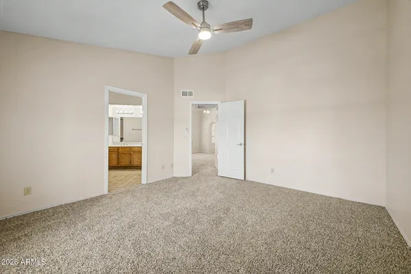 an empty room with closet and a ceiling fan