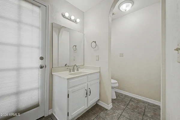 a view of bathroom with a toilet sink and mirror