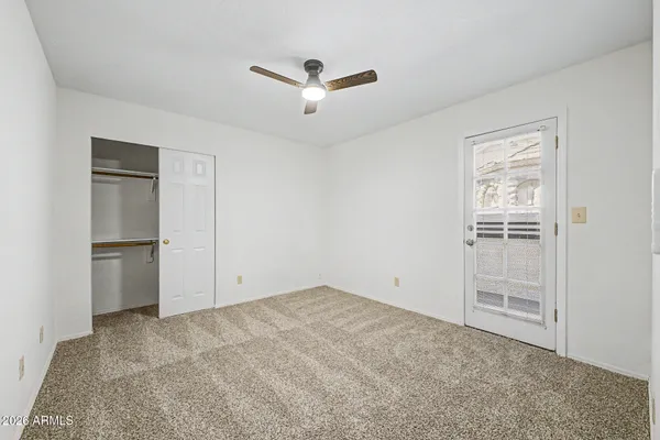 an empty room with closet and windows
