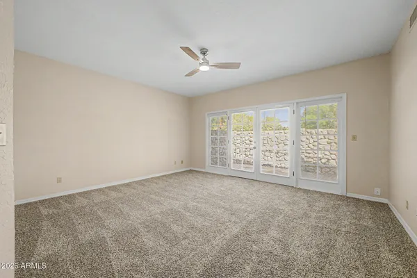 an empty room with windows and ceiling fan view