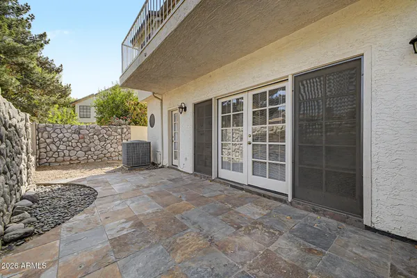 a view of empty room with a large window and potted plants