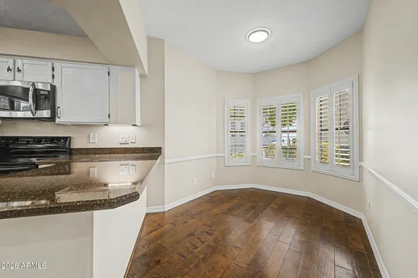 a kitchen with stainless steel appliances granite countertop a sink stove and white cabinets with wooden floor