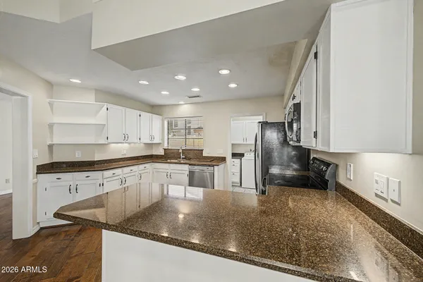 a kitchen with stainless steel appliances granite countertop a sink a stove and a refrigerator