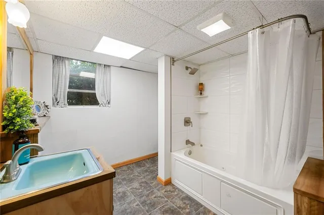 a bathroom with a tub shower and sink