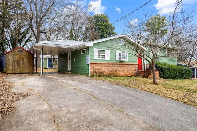 a view of a house with a yard and large tree