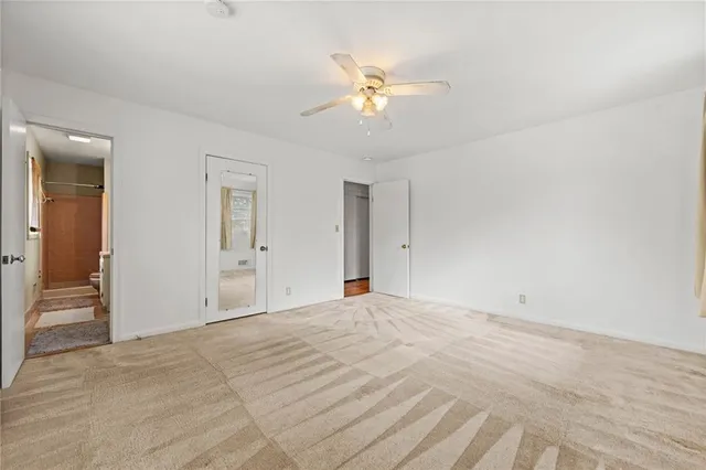 a view of an empty room with a chandelier fan