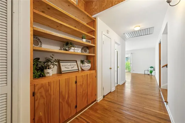a view of a hallway with wooden floor and staircase