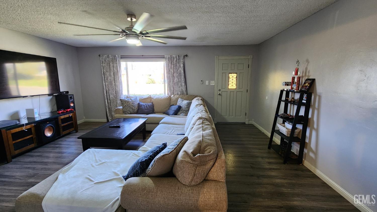 Undisclosed Address Bakersfield, CA 93306 - Photo 21 of 22 a living room with furniture and a flat screen tv with wooden floor