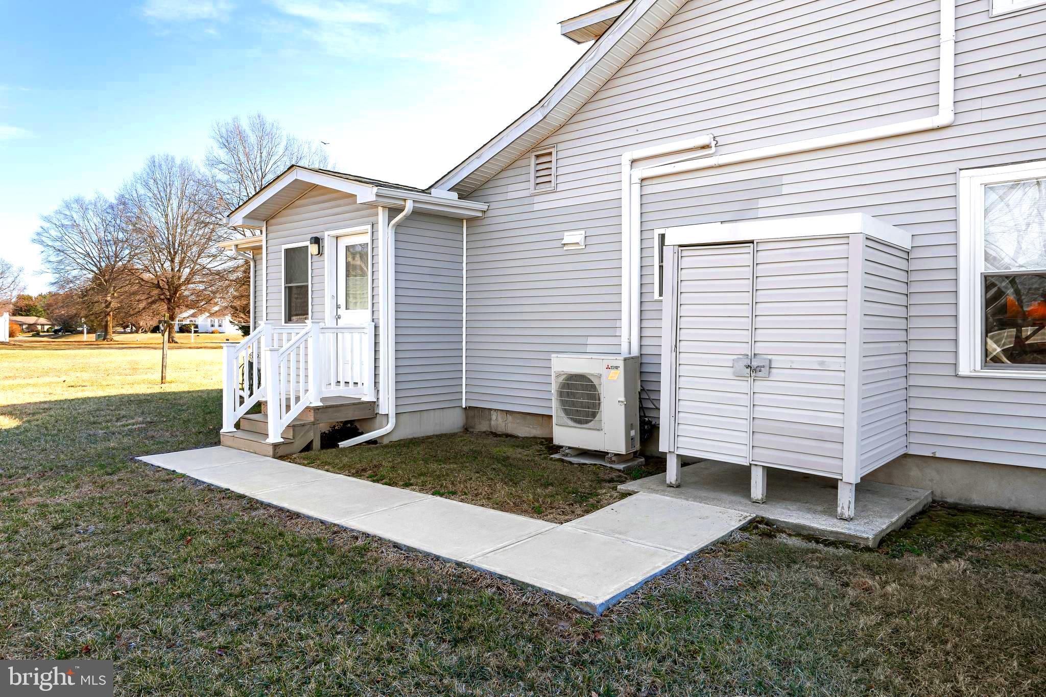 19773 Old Landing Road Rehoboth Beach, DE 19971 - Photo 14 of 54 a view of a white house with yard and a chair