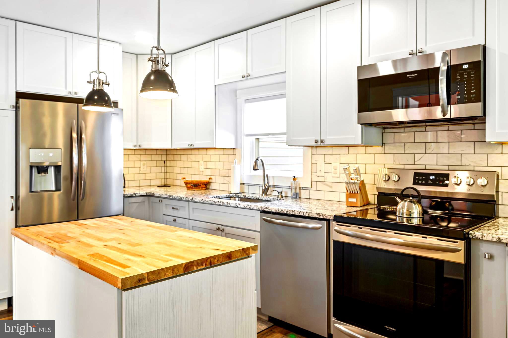 19773 Old Landing Road Rehoboth Beach, DE 19971 - Photo 2 of 54 a kitchen with stainless steel appliances granite countertop a sink stove and refrigerator
