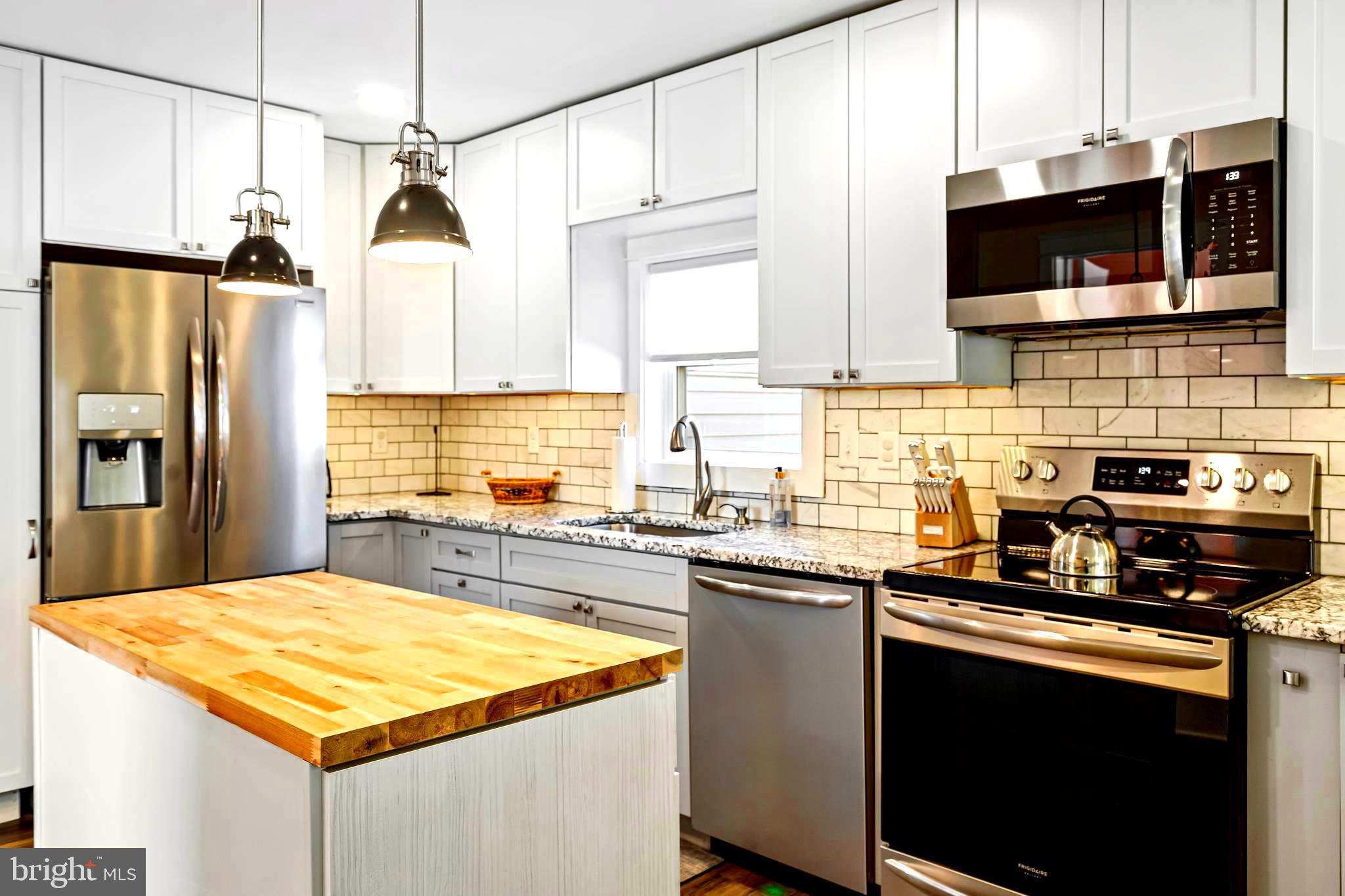 19773 Old Landing Road Rehoboth Beach, DE 19971 - Photo 10 of 54 a kitchen with stainless steel appliances granite countertop a sink stove and refrigerator