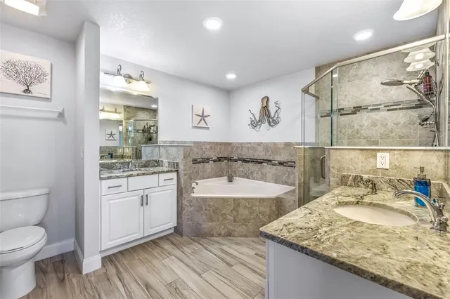 a bathroom with a granite countertop sink toilet and shower