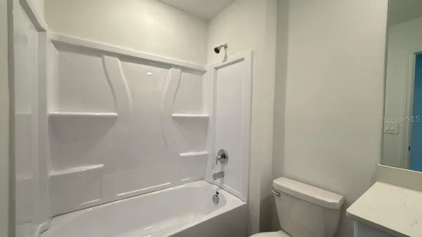 a white bath tub sitting next to a white toilet and a shower