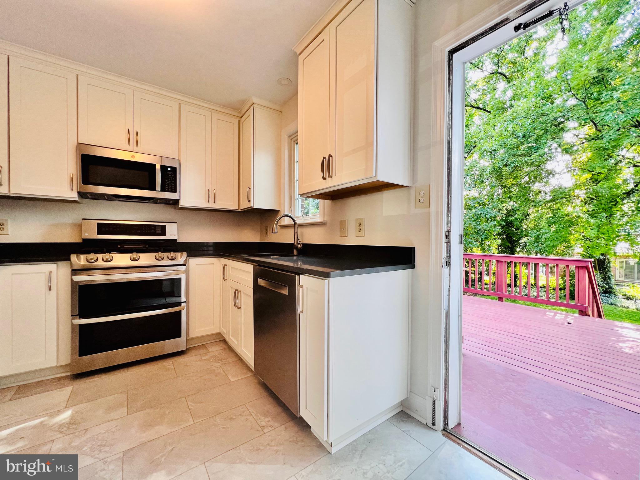 7208 Exeter Road Bethesda, MD 20814 - Photo 7 of 26 a kitchen with stainless steel appliances a stove a sink and a microwave