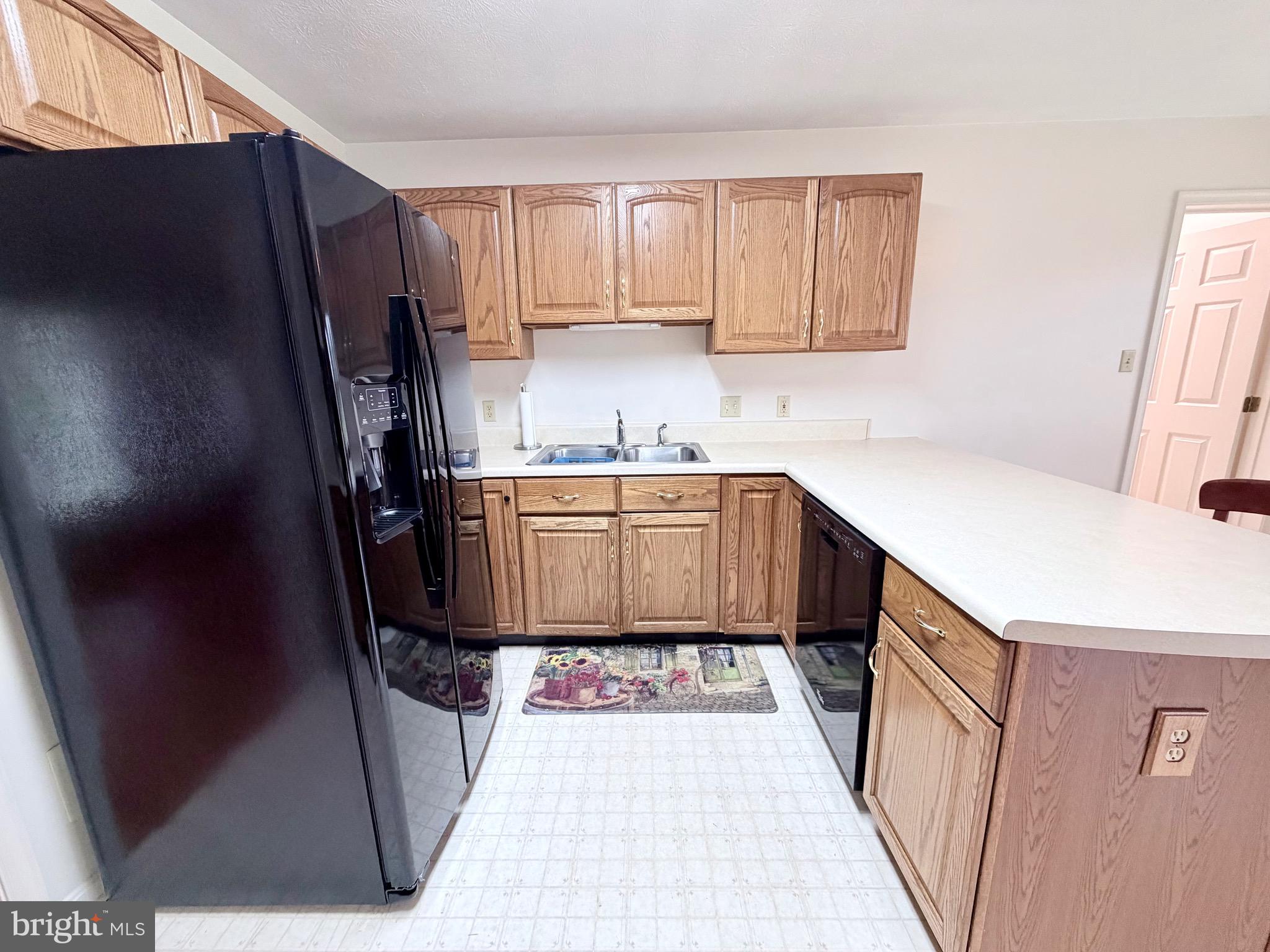 78 Brook Creek Road Toms Brook, VA 22660 - Photo 12 of 43 a kitchen with a sink a refrigerator a window and cabinets