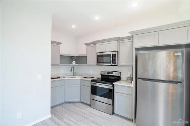a kitchen with white cabinets stainless steel appliances and sink