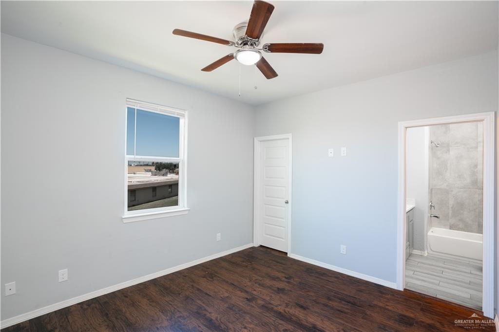 521 North Cynthia Street, Unit 2 McAllen, TX 78501 - Photo 7 of 21 an empty room with wooden floor and windows