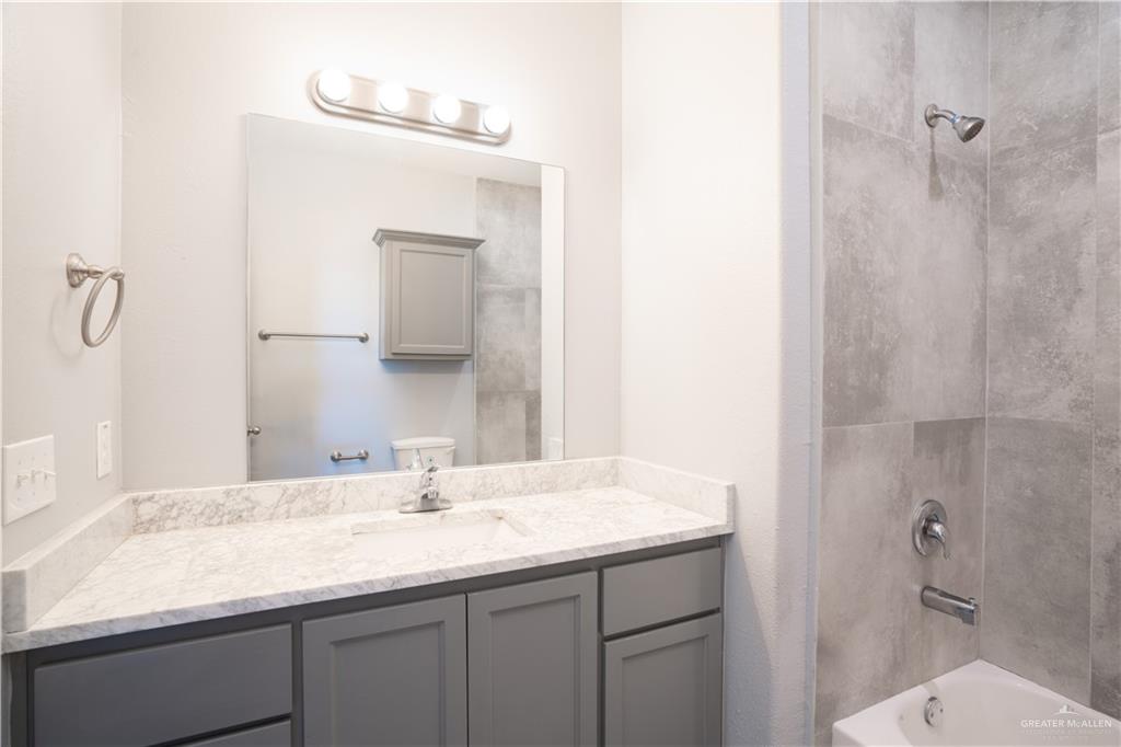 521 North Cynthia Street, Unit 2 McAllen, TX 78501 - Photo 8 of 21 a bathroom with a granite countertop sink a toilet and shower