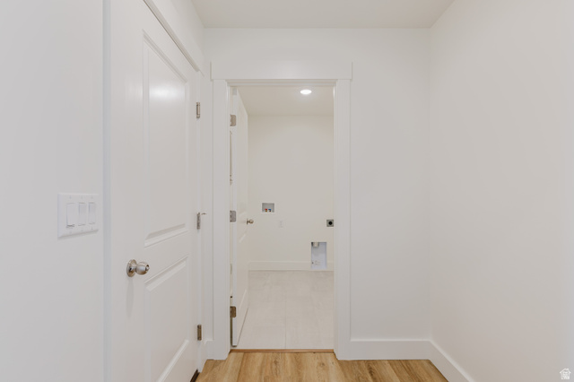 433 North 600 West Smithfield, UT 84335 - Photo 21 of 40 Hallway featuring wood-finish flooring, white doors with brushed nickel hardware, and an open doorway revealing a utility area with hookups and recessed lighting