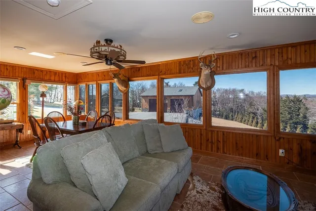 a living room with furniture a fireplace and large windows