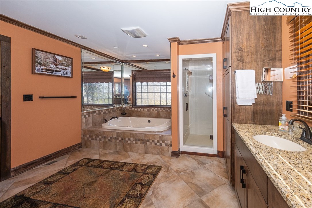 186 Woodcrest Road Glade Valley, NC 28627 - Photo 21 of 50 a spacious bathroom with a granite countertop sink a toilet and shower