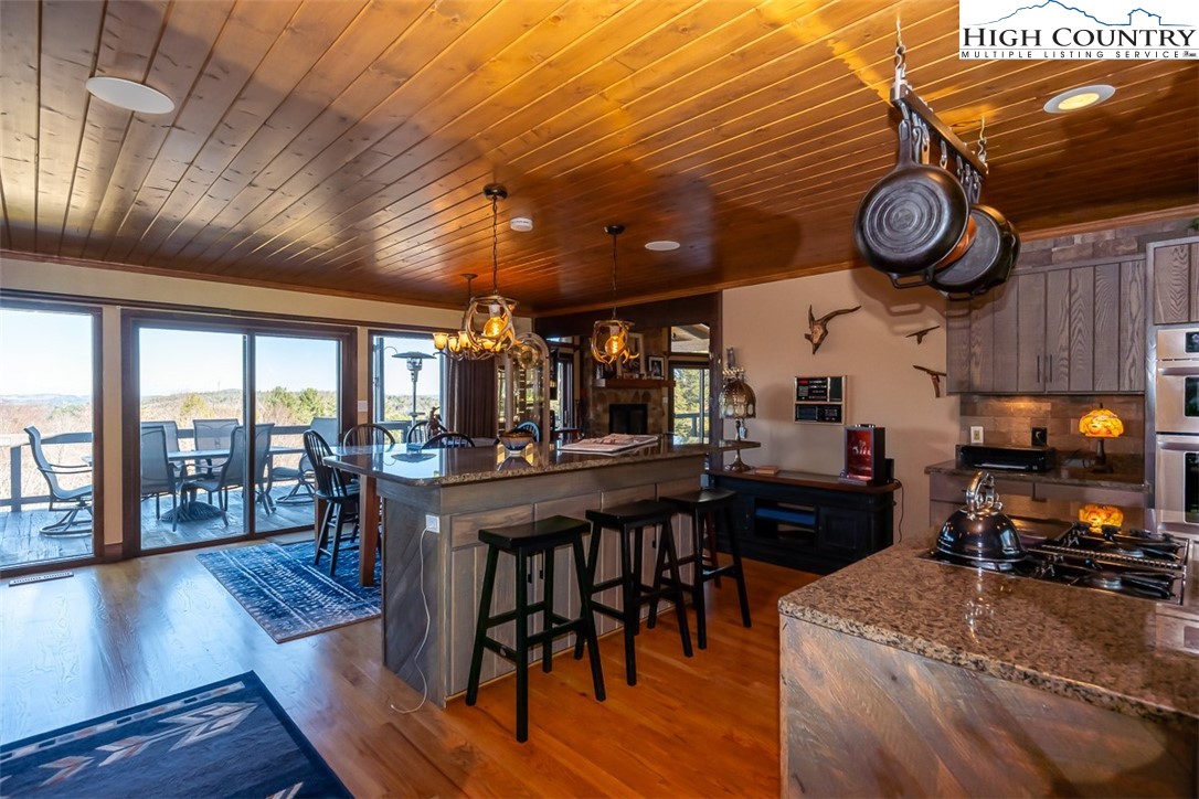 186 Woodcrest Road Glade Valley, NC 28627 - Photo 21 of 50 a kitchen with stainless steel appliances granite countertop a stove a refrigerator a dining table and chairs with wooden floor
