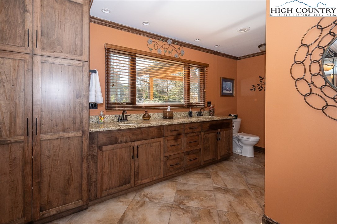 186 Woodcrest Road Glade Valley, NC 28627 - Photo 22 of 50 a bathroom with a sink a toilet and a large mirror