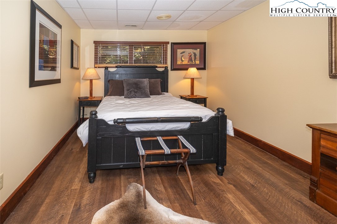 186 Woodcrest Road Glade Valley, NC 28627 - Photo 31 of 50 a bedroom with a bed and wooden floor