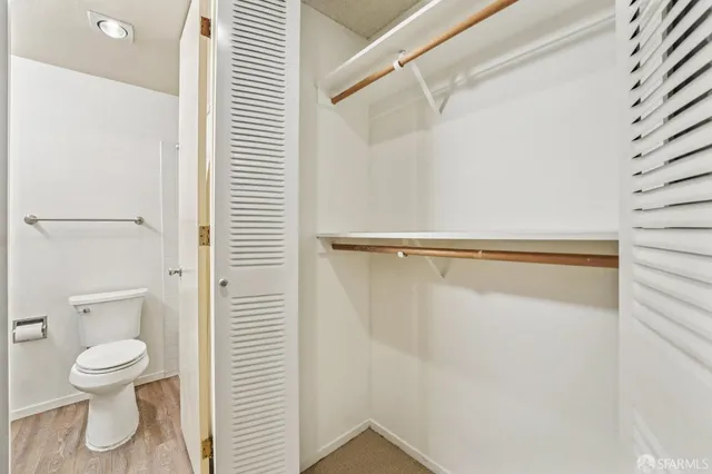 a white toilet sitting next to a shower