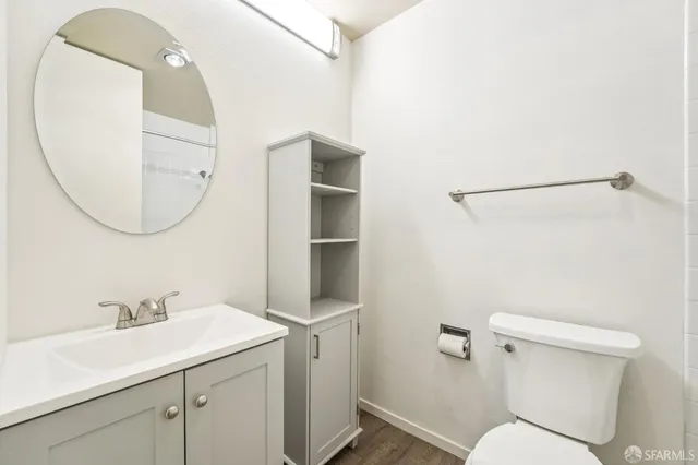a bathroom with a sink mirror vanity and toilet