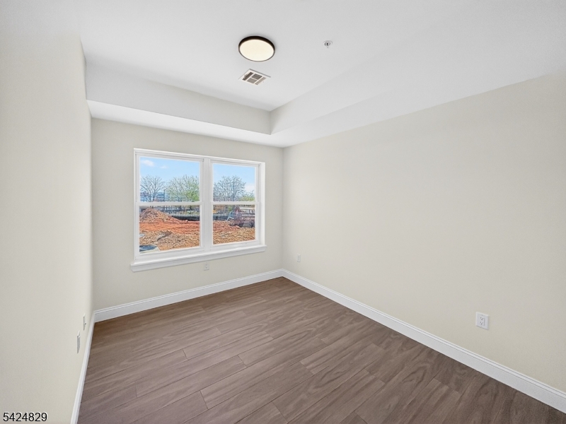262 Hunterdon Street, Unit 1 Newark, NJ 07103 - Photo 11 of 31 an empty room with wooden floor and windows