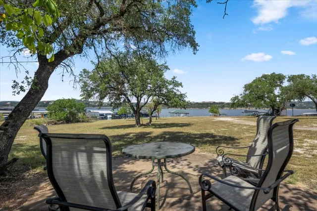 a dining hall with stainless steel appliances granite countertop a stove kitchen island a table and chairs with wooden floor