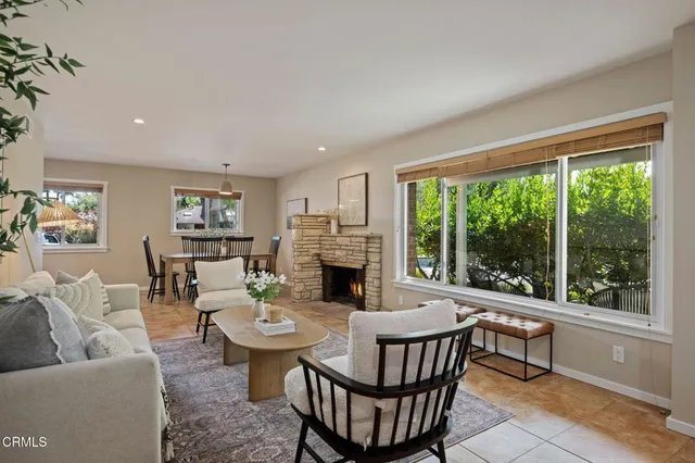 a living room with fireplace furniture and a large window