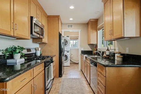 a kitchen with stainless steel appliances granite countertop a sink stove and refrigerator