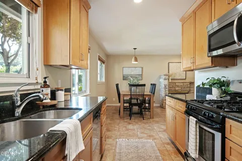 a kitchen with granite countertop a sink appliances and cabinets