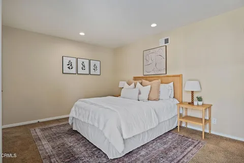 a bedroom with a bed and a lamp with the wooden floor
