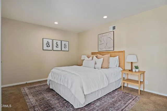 a bedroom with a bed and a lamp with the wooden floor