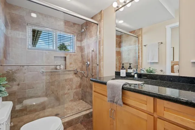 a large bathroom with a granite countertop tub a sink and a large mirror