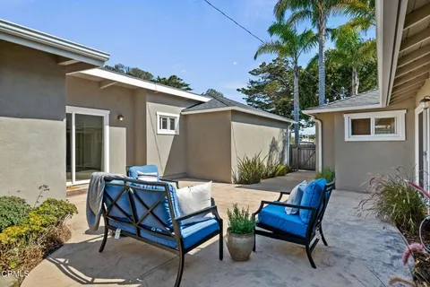 a view of a house with backyard and sitting area