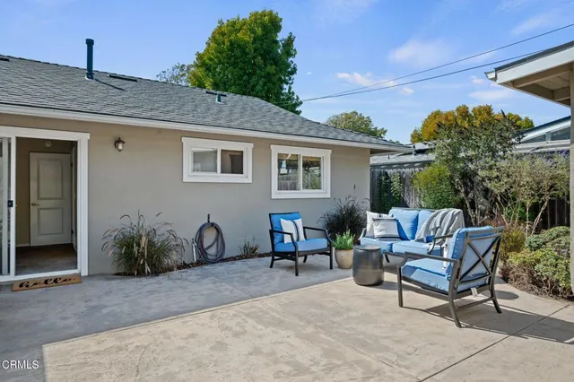 a backyard of a house with table and chairs