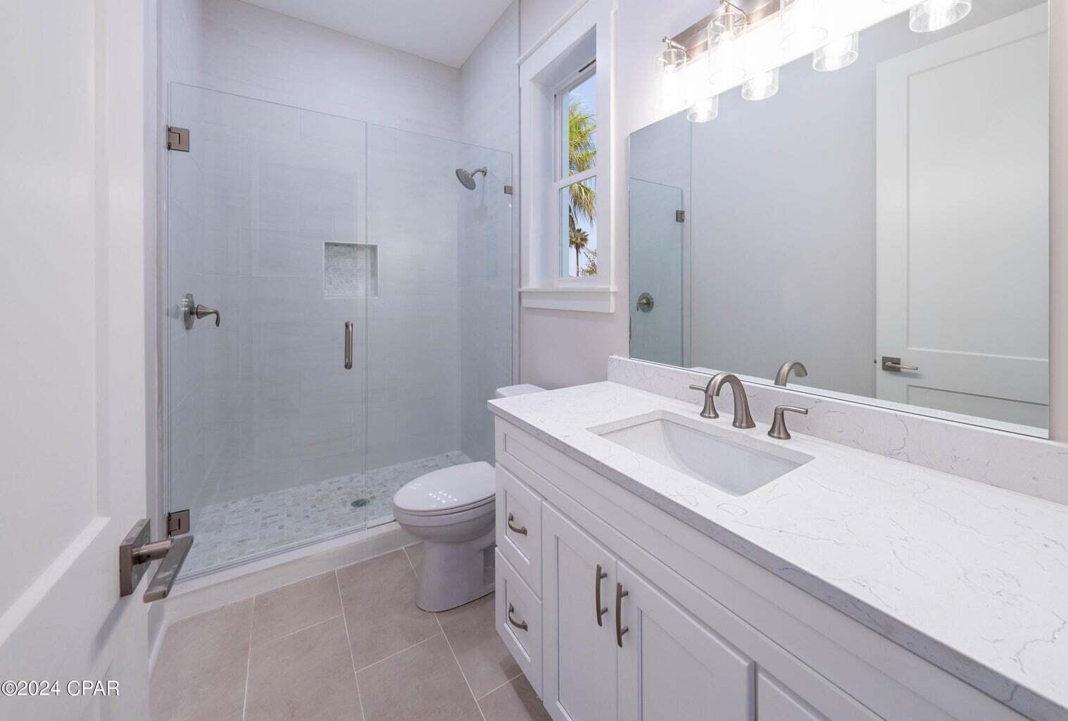 142 7th Street Santa Rosa Beach, FL 32459 - Photo 18 of 22 a bathroom with a granite countertop sink a toilet and a mirror