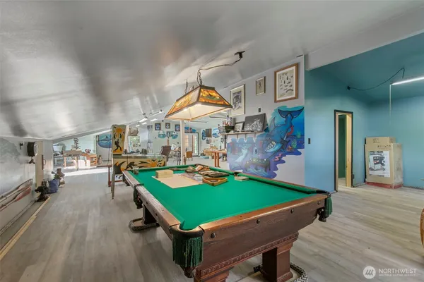 a room with pool table and chairs