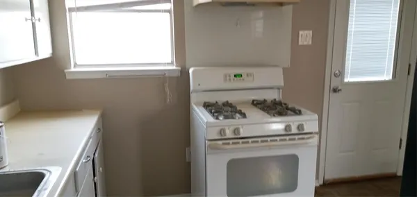 a kitchen with a stove and a window