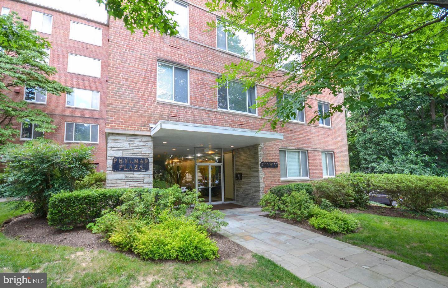 4100 W Street Northwest, Unit 410 Washington, DC 20007 - Photo 3 of 18 a front view of a house with garden and trees