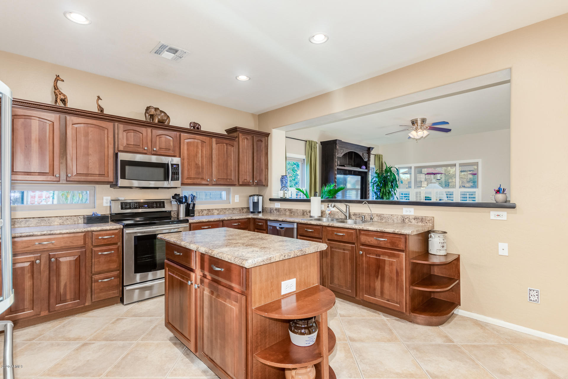 4549 East Ruffian Road Gilbert, AZ 85297 - Photo 13 of 52 a kitchen with stainless steel appliances granite countertop a stove top oven a sink dishwasher and a microwave oven with large trees