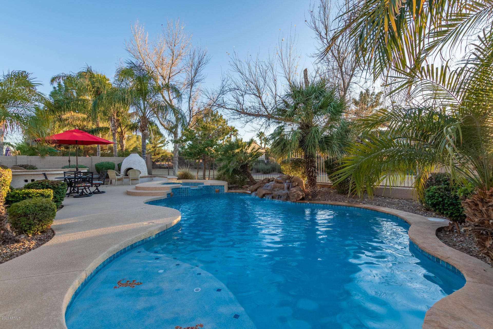 4549 East Ruffian Road Gilbert, AZ 85297 - Photo 19 of 52 a swimming pool with outdoor seating and trees